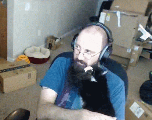 a man with headphones is petting a cat