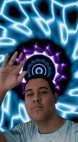 a man is in front of a psychedelic picture with the reflection of his face on the wall