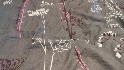 a gray blanket with purple flowers and vines on it