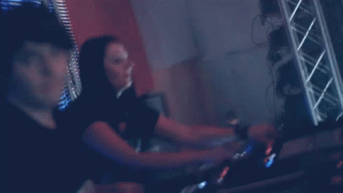 a woman and a man playing music on a dj mixer