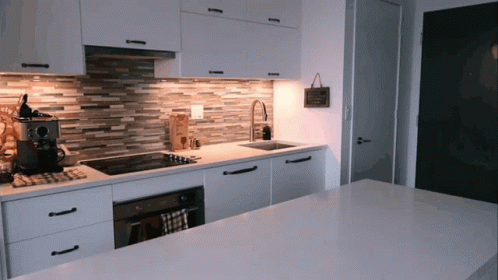 a kitchen with all white cabinets and a large counter