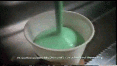 a glass full of green liquid is sitting on the counter