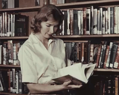 a woman in white shirt reading a book in a liry