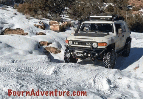 this jeep is traveling on a snowy trail