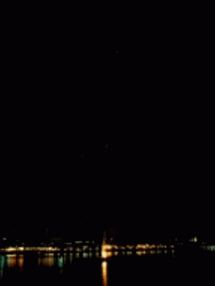 a plane is flying low over the water at night