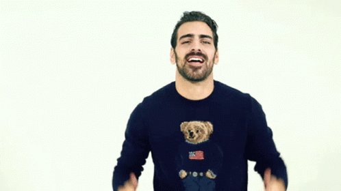 a man laughing while standing up wearing a t shirt