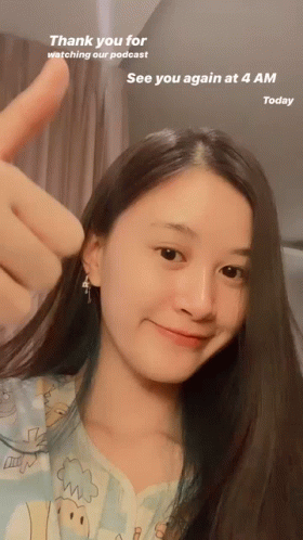 young asian woman posing with peace sign in front of her