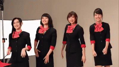a group of people in identical outfits with a projector in the background