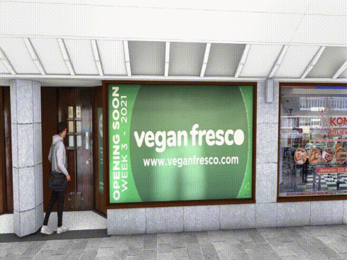 a man walking into a vegan fresh on the sidewalk