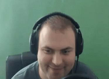 man wearing headphones using laptop and playing video game