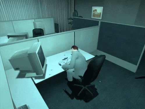 the person is sitting at a desk using a computer