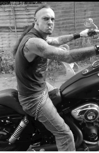 black and white image of man on motorcycle posing