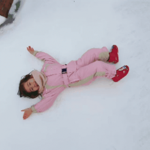 a person laying down in the snow on their feet