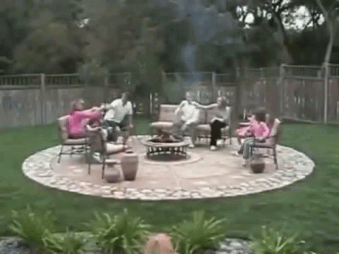 several people sitting around in chairs outside near an over sized fire pit