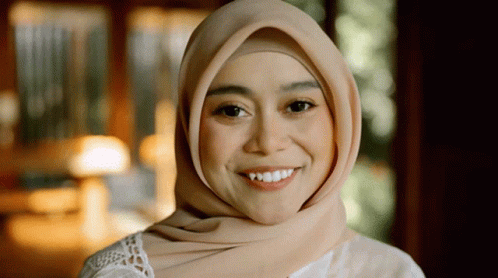 a woman in hijab smiling for the camera