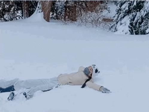 a man laying on the snow and a man laying back on the snow