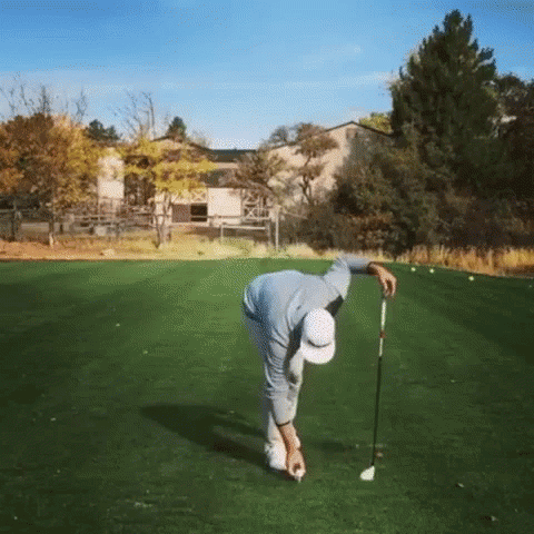 a man hitting a golf ball into a golf club