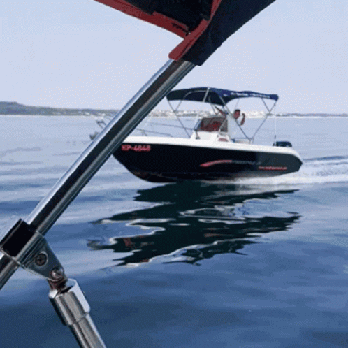 a speedboat with a sail and poles is floating in the water