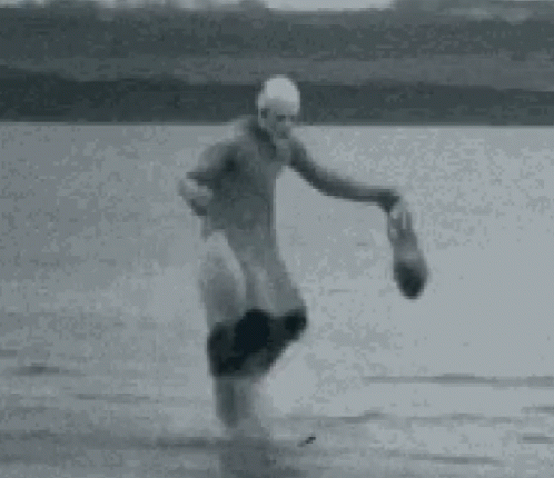 a man playing catch on a beach near the ocean