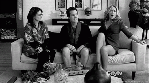 a man and two women sitting on a couch with an open mouth