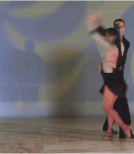 a couple dancing on a tiled floor in the middle of a dance