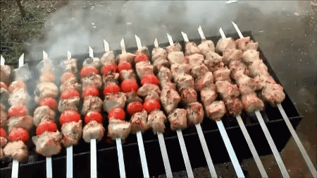 several skewers with blue and white food on them cooking