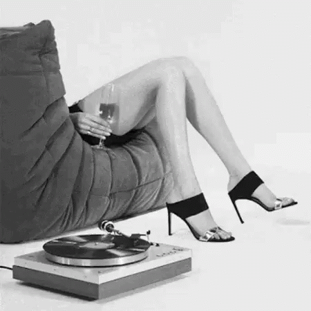 woman sitting in chair with vinyl record player