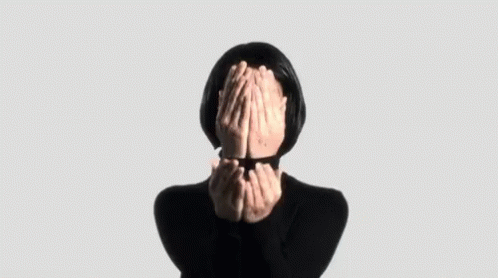 a woman with her hands to her face and hands covering her eyes