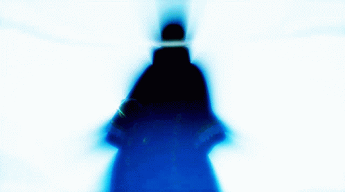 the silhouette of a person standing with a cell phone