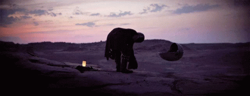 a person standing on a rock with their head down