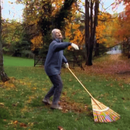 an older man who is mopping the yard with a lawn broom