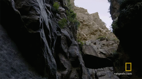 a narrow rocky path that is filled with water
