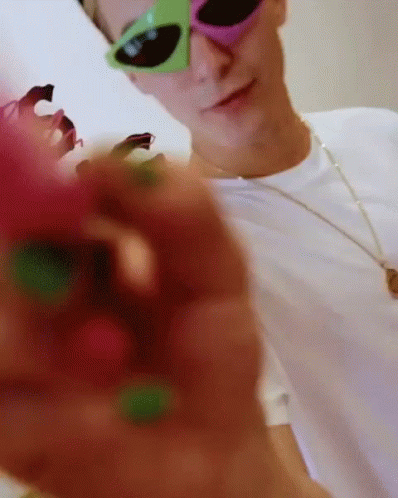the man is wearing pink sunglasses and green glasses