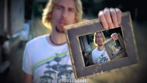 a man holding up a old picture frame with pos