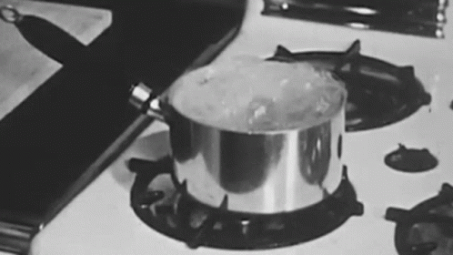 a metal pot with ice inside sitting on a stove