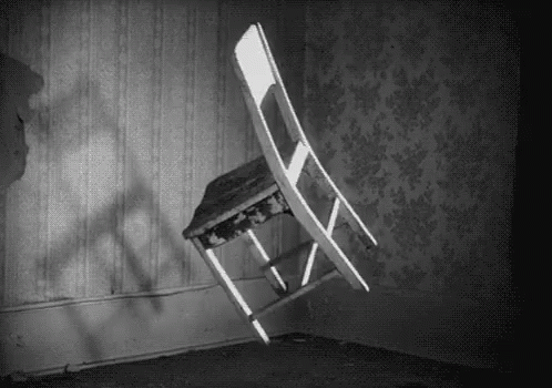 a wooden folding chair in a room next to a wall