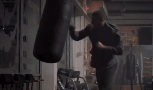the person is practicing boxing in a room with chairs