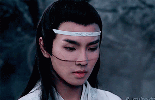 a young asian woman is wearing a white head piece