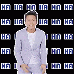 a person standing in front of a backdrop with the name ha ha written on it