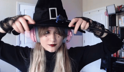 a woman dressed in witch makeup poses for the camera