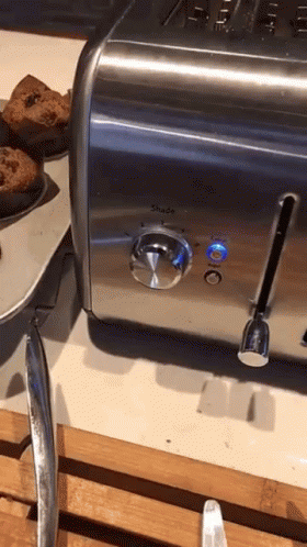 the toaster is beside some cupcakes that are on plates