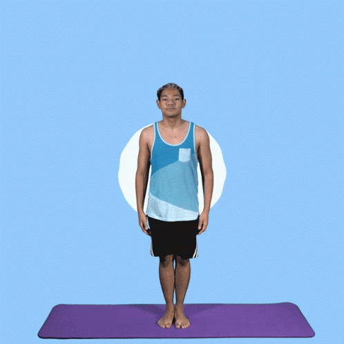 a man stands on a yoga mat in front of an orange wall