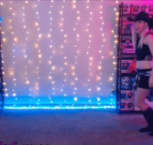 a woman that is walking around in front of some lights