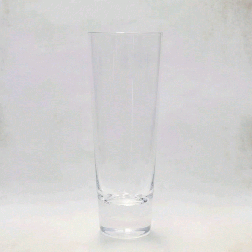 an empty glass sitting on a table in a room