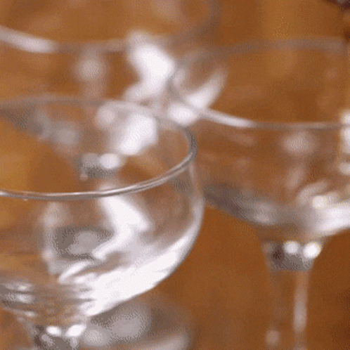 four glasses on a table one is empty