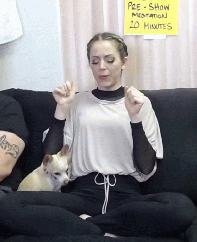 woman sitting on couch with two dogs on her lap