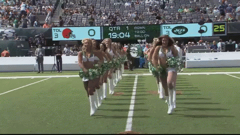 four cheerleaders walking on the football field