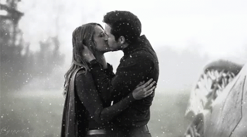 a couple kiss each other while holding an umbrella