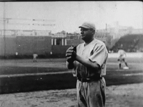 a black and white pograph of a man holding a baseball bat