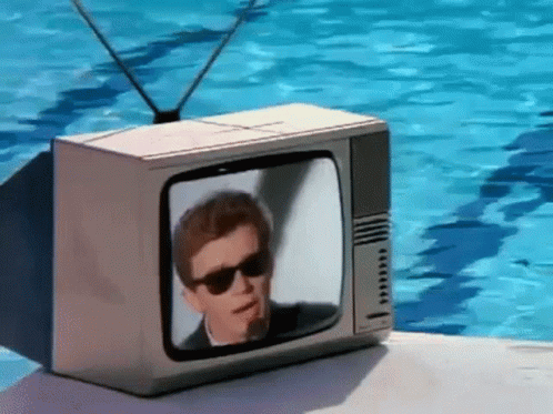 a blue man with glasses on his face in front of an old television